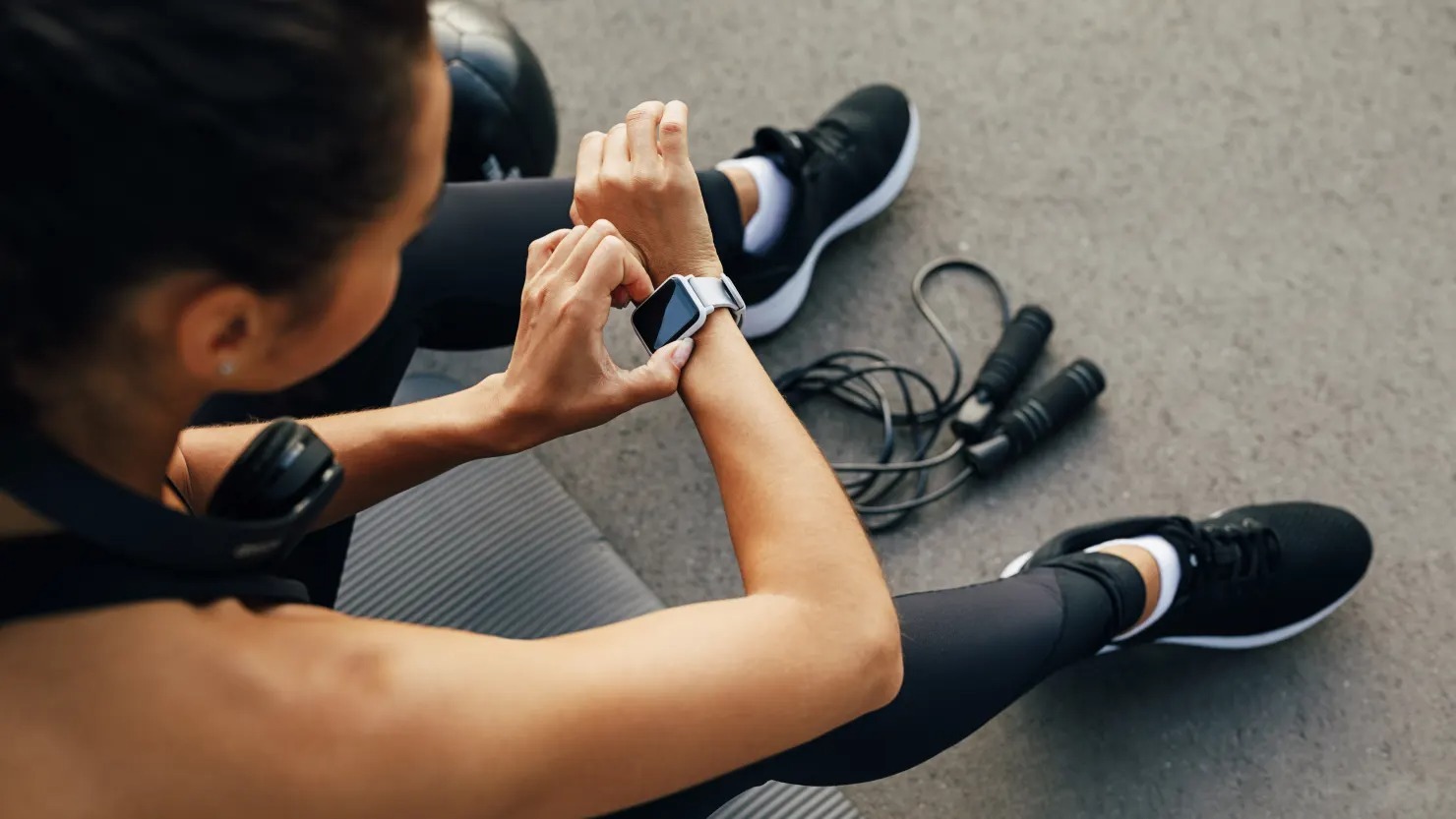 Gesundheitsüberwachung mit Smartwatch - Sportliche Person kontrolliert Fitnessdaten nach dem Training für einen aktiven Lebensstil